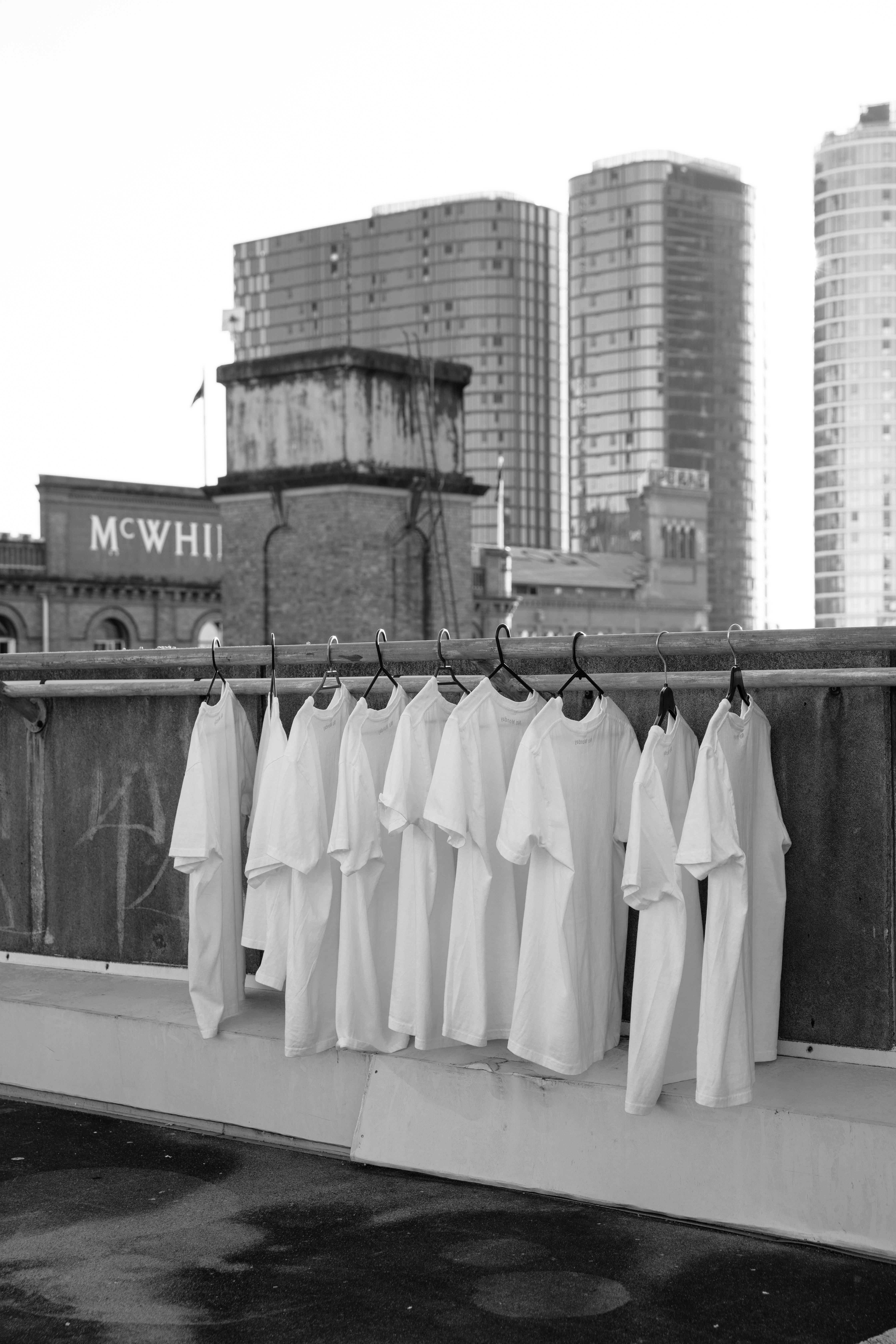 Row of blank white t-shirts on hangers, ready for private-label branding
